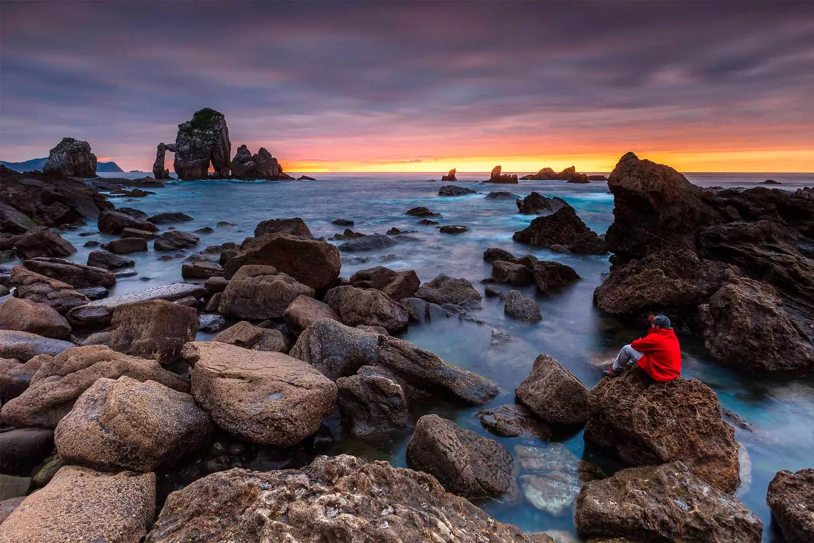 San Juan de Gaztelugatxe'nin kayalık sahillerine hayran olan adam