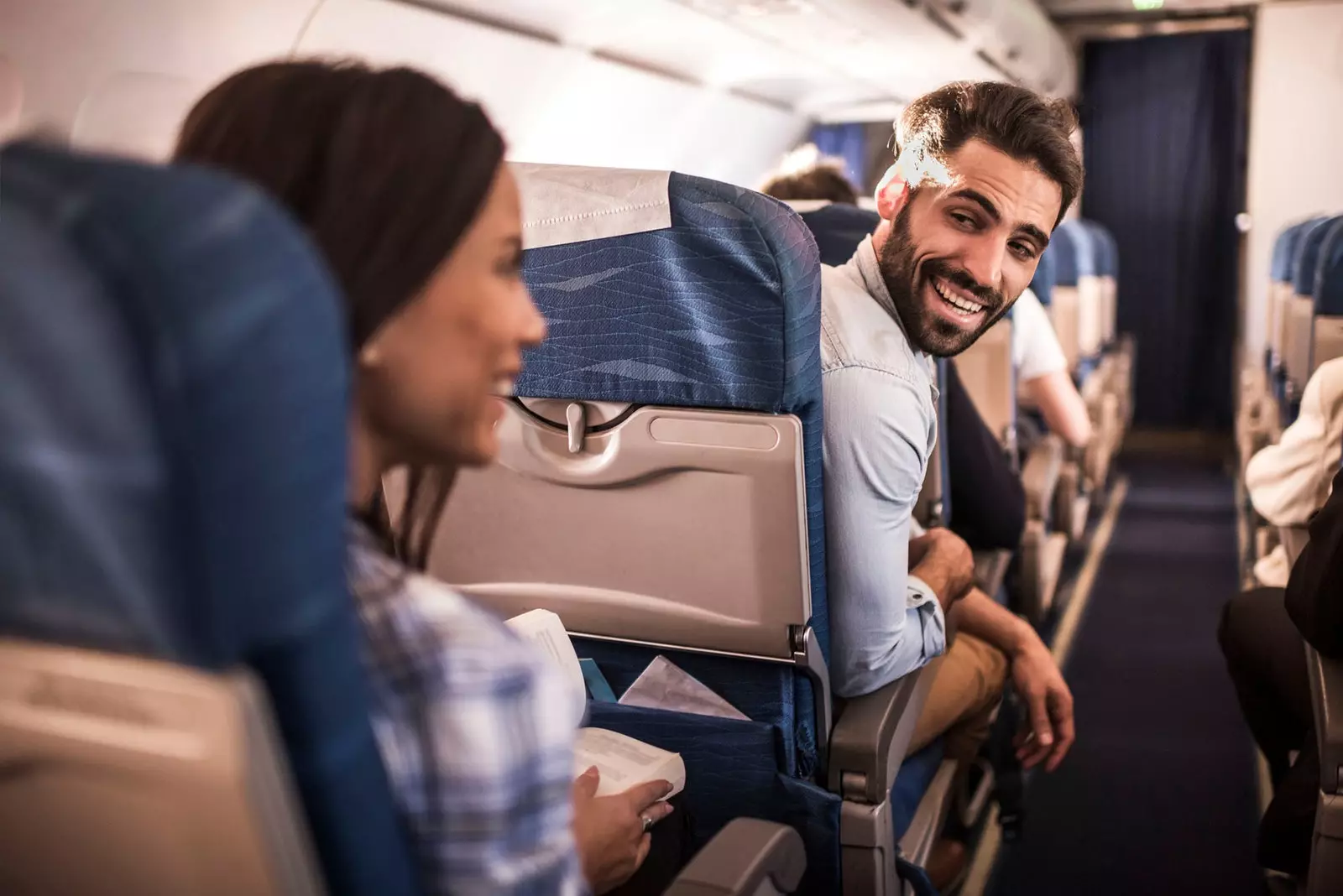 man and woman talking on plane