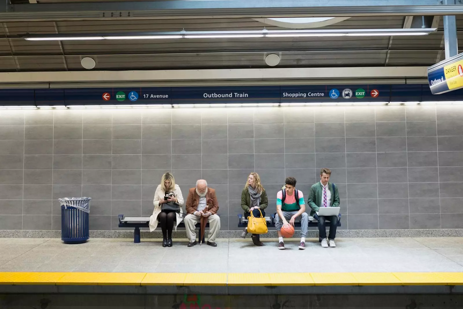 personnes assises attendant le train