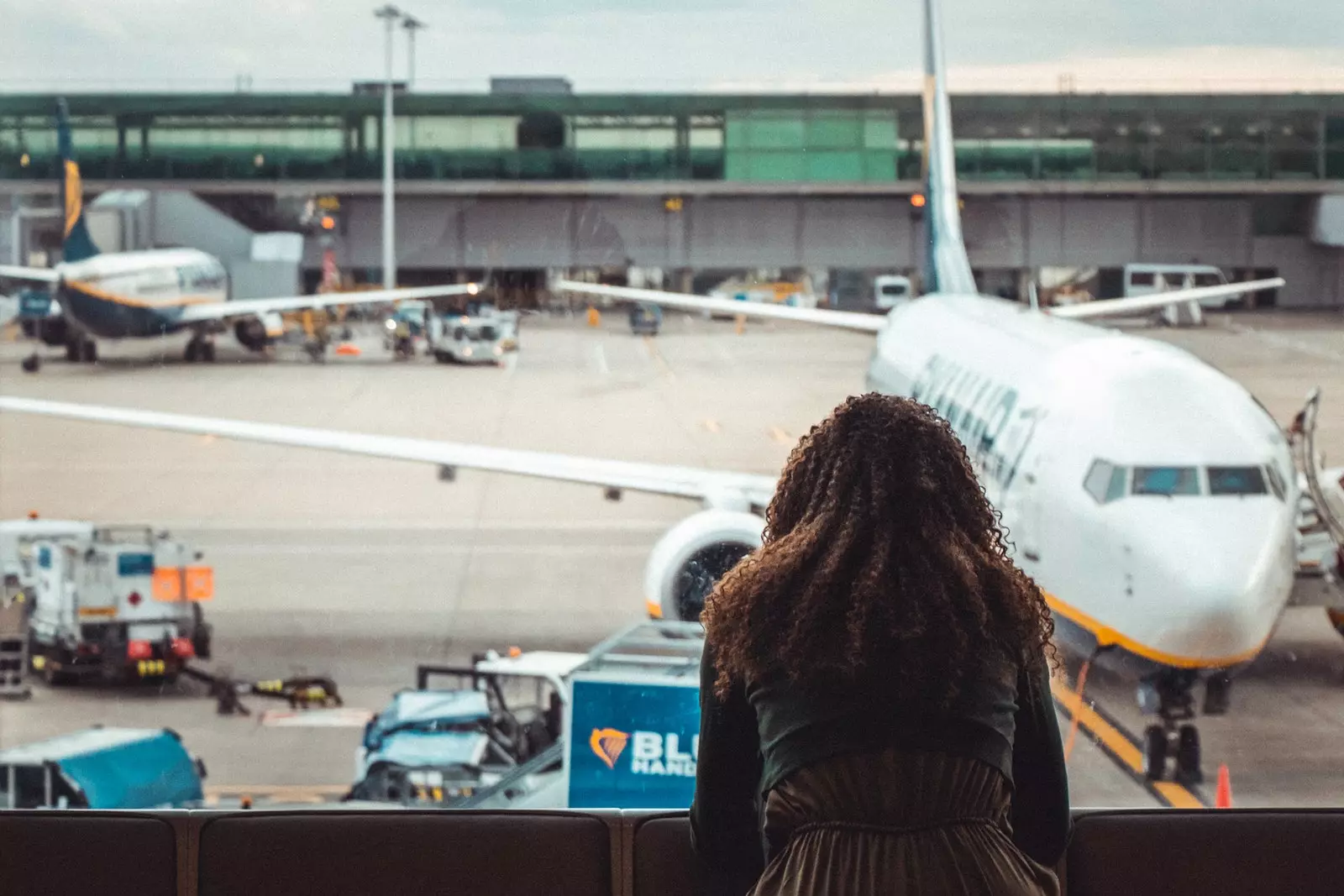 Wanita melihat ke luar jendela di bandara