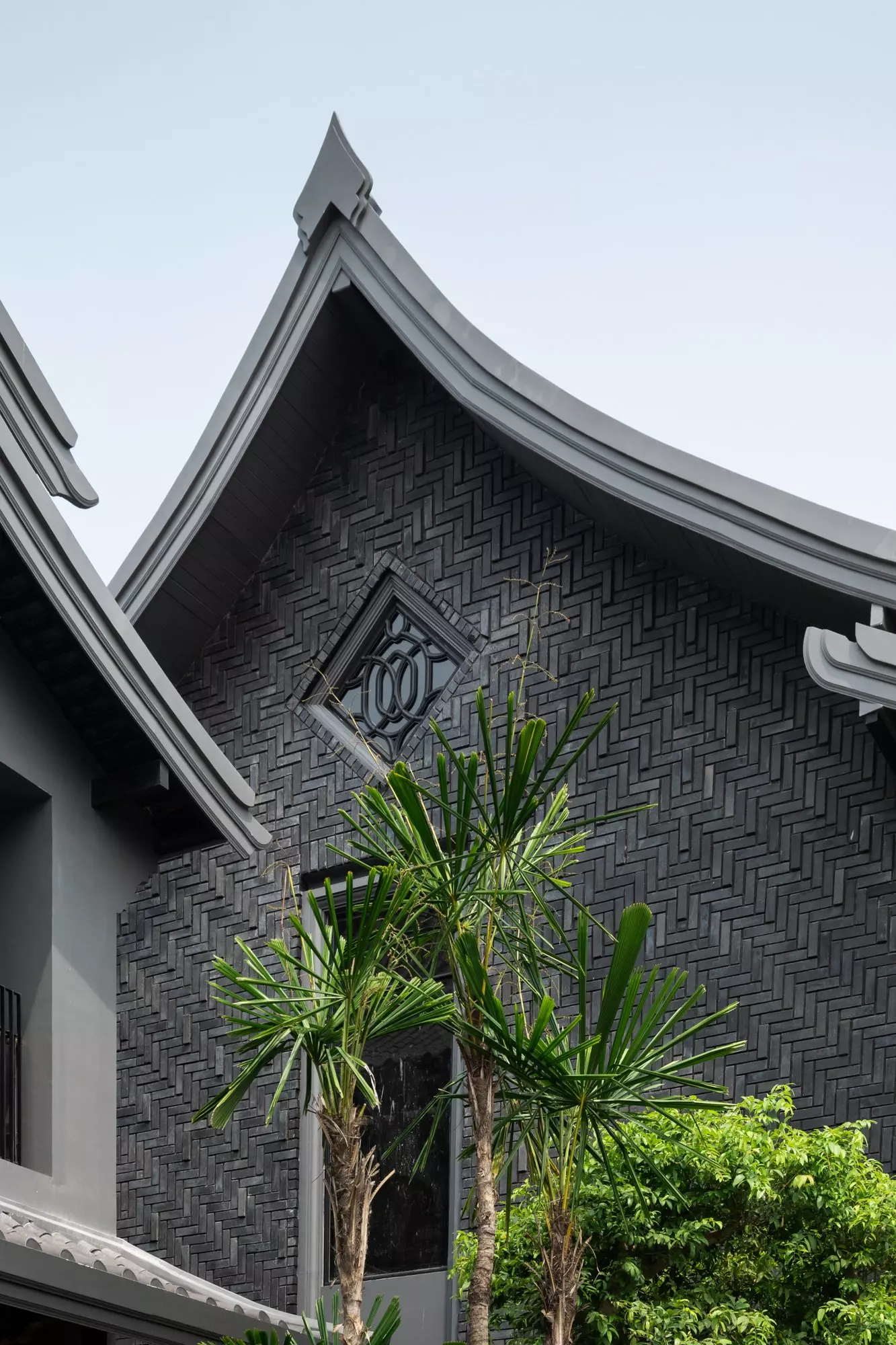 Eines der Gebäude im Dorf Kalm in Chiang Mai mit seiner eleganten grauen Fassade mit geometrischen Mustern.