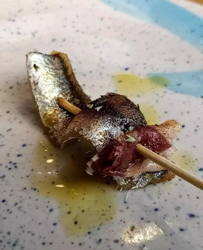 Brochette de bocarte marinée au jambon de canard salé, poudre de tomate séchée et galmesano.