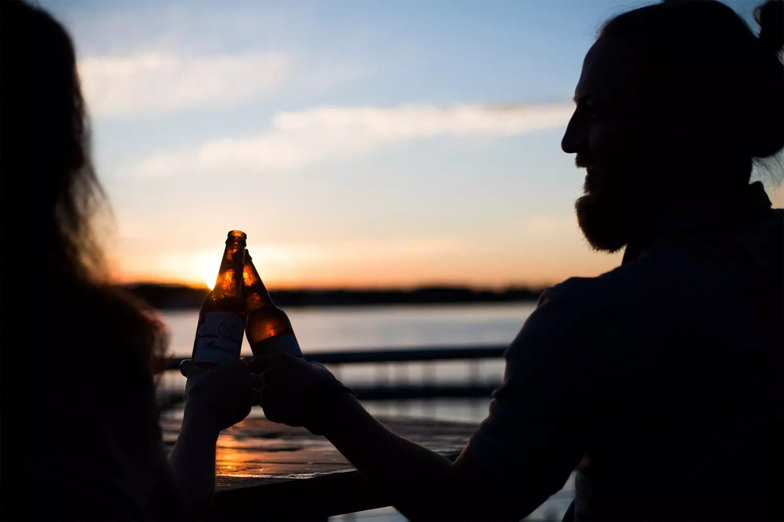 逆光でビールを飲む二人