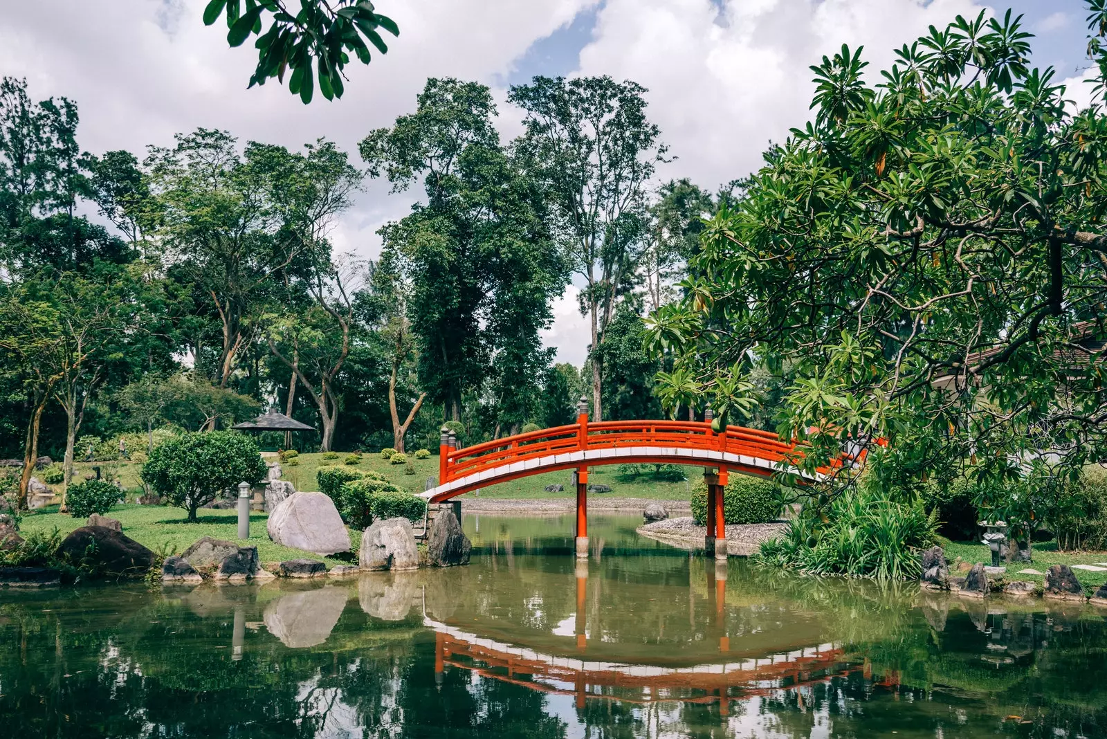 Daraja jekundu la mbao juu ya bwawa katika bustani ya Kijapani ya Jurong Lake Gardens Singapore