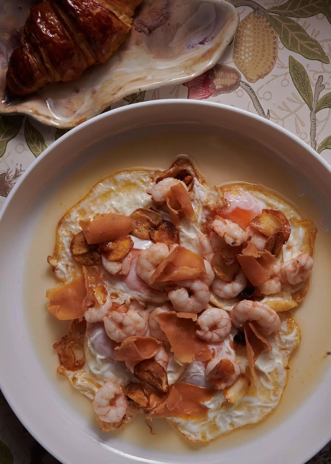 Ovos fritos ao ar livre, camarão ao alho e atum almadraba salgado com croissant de manteiga quente no Bugao Madrid