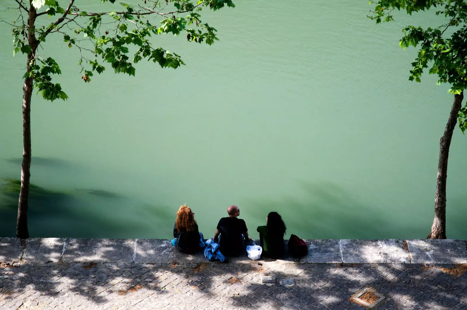 Genieten van de koelte aan de oevers van de rivier de Tiber in Rome