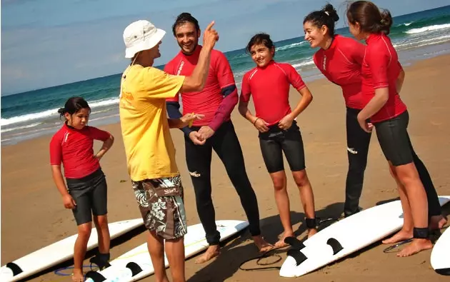 Letnia plaża macha dzieci i deski surfingowe