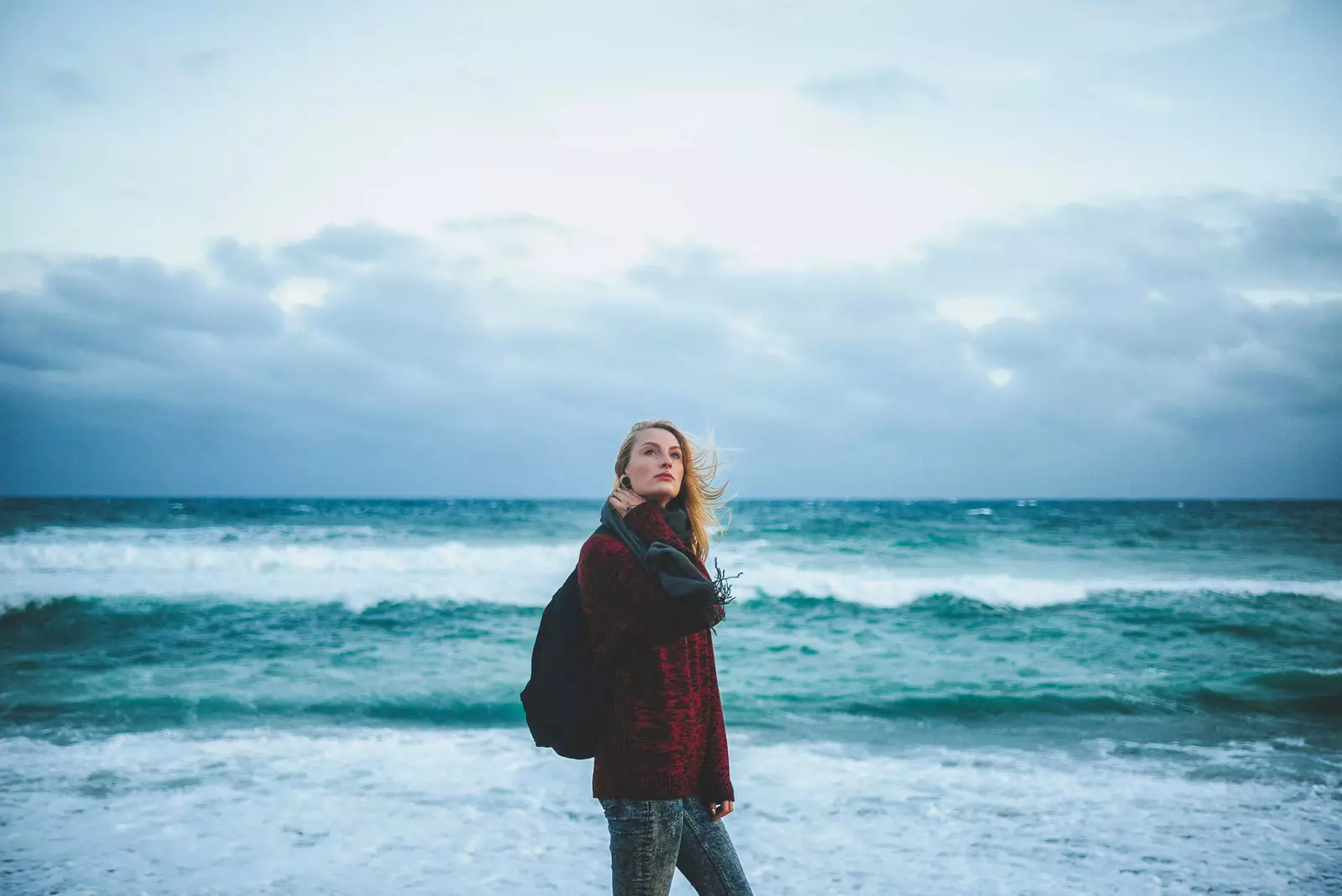 Jente på stranden i dårlig vær