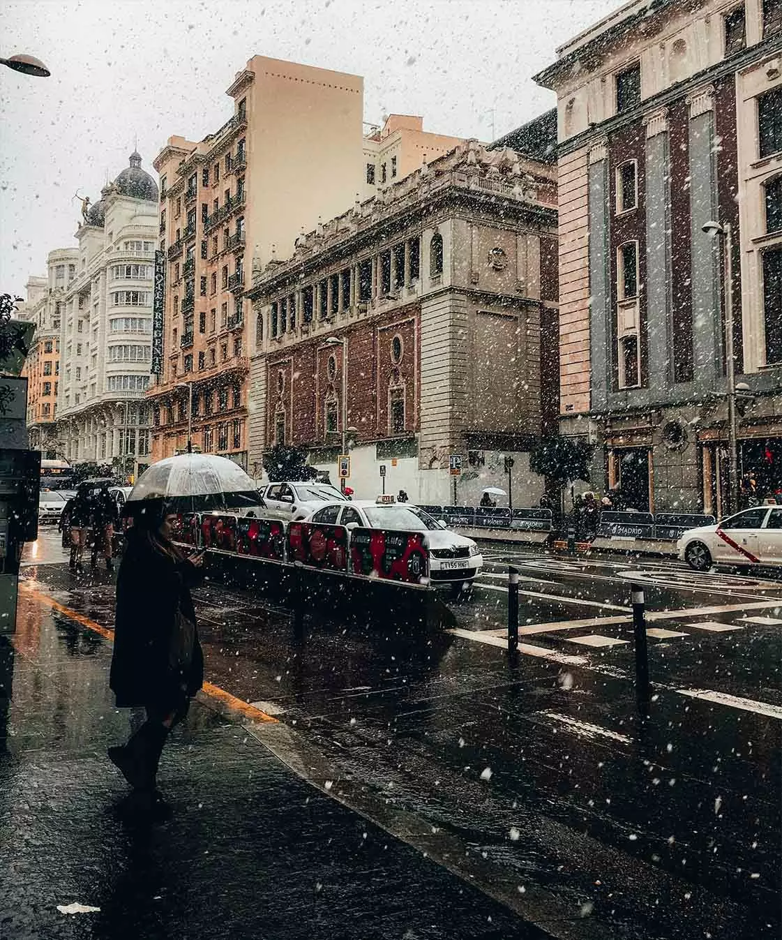 homme marchant dans madrid sous la pluie