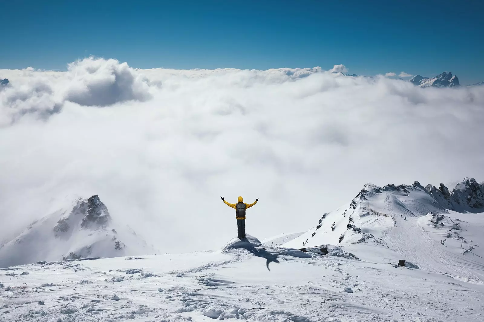 Un alpinist ajunge pe un vârf înzăpezit.