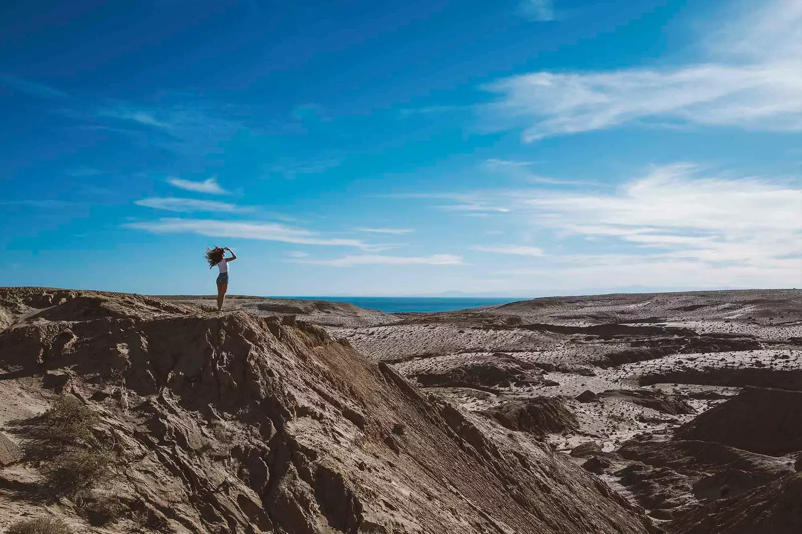 meisje dat vanaf het zand naar de zee kijkt