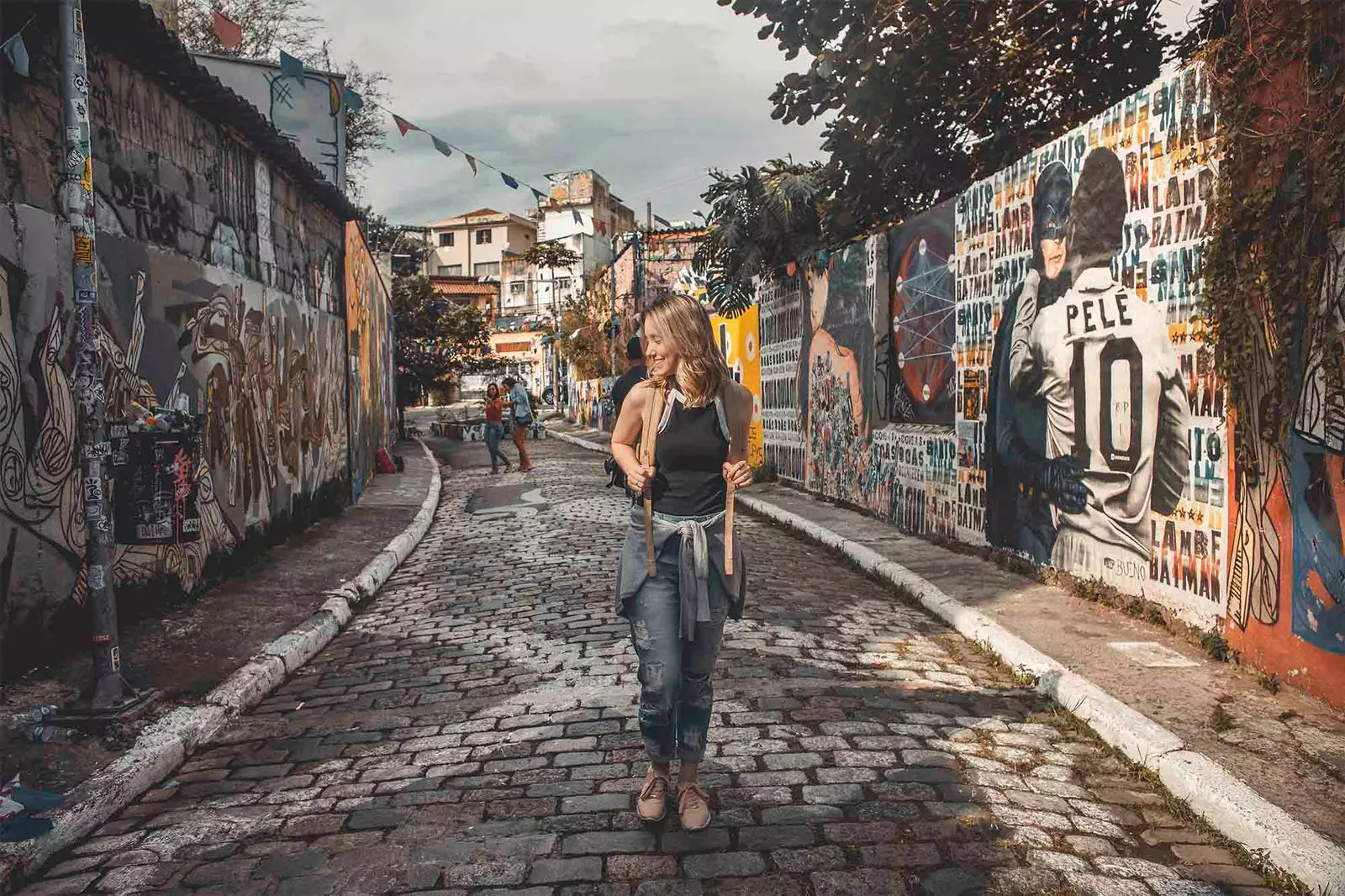 menina andando na rua em frente a paredes de graffiti