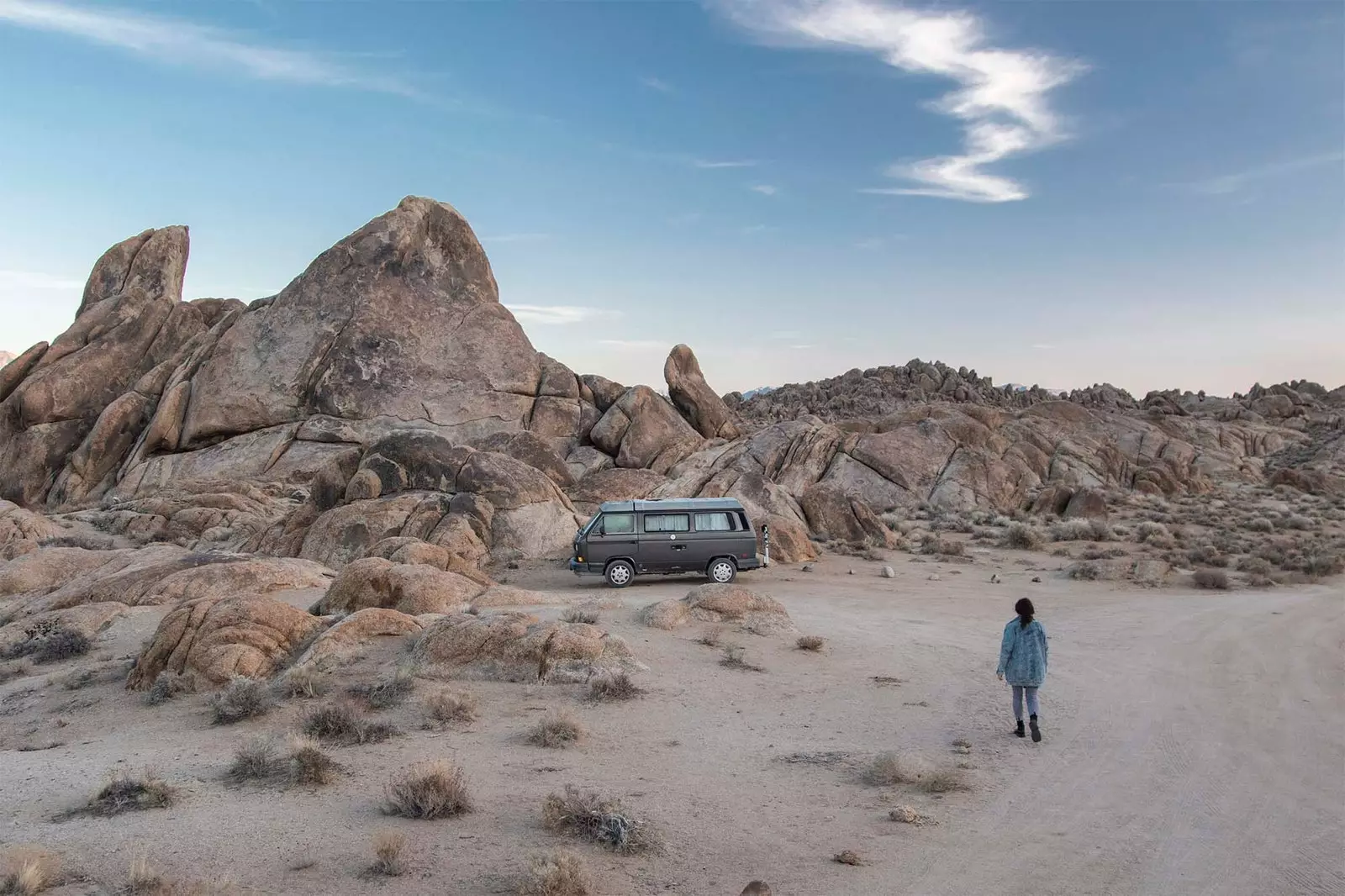 menina caminhando em direção a caravana no deserto