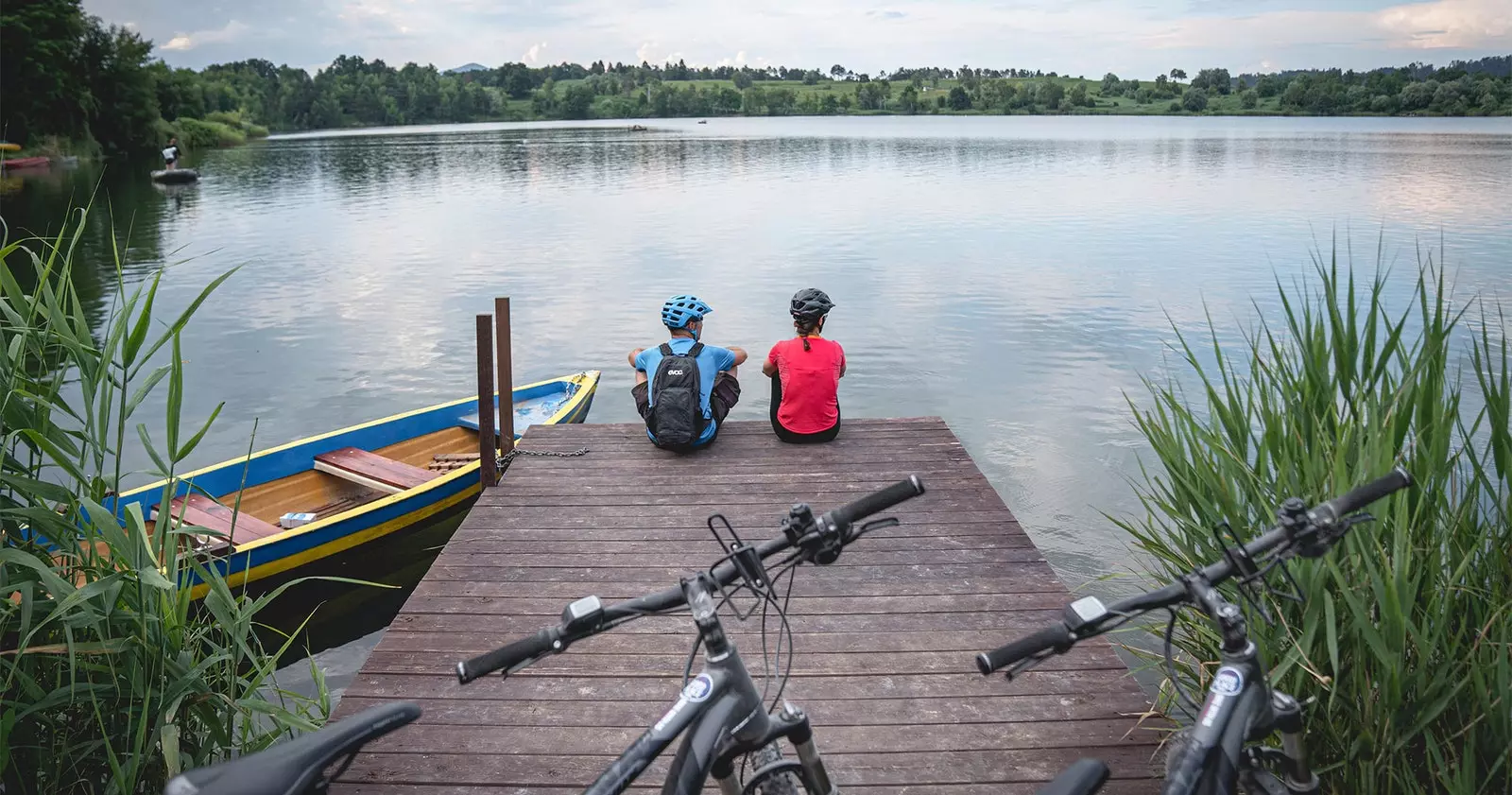 velosipedlar bilan dokda dam olayotgan ikki kishi