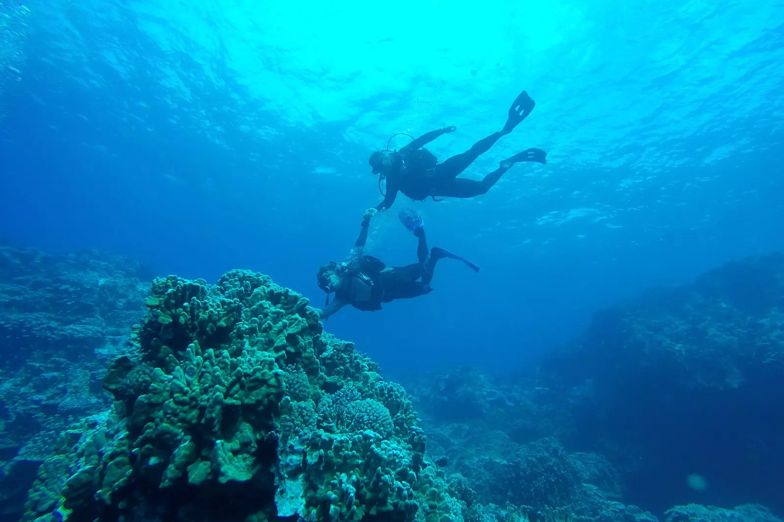 Zwee Scuba Taucher schwammen tëscht Fielsen