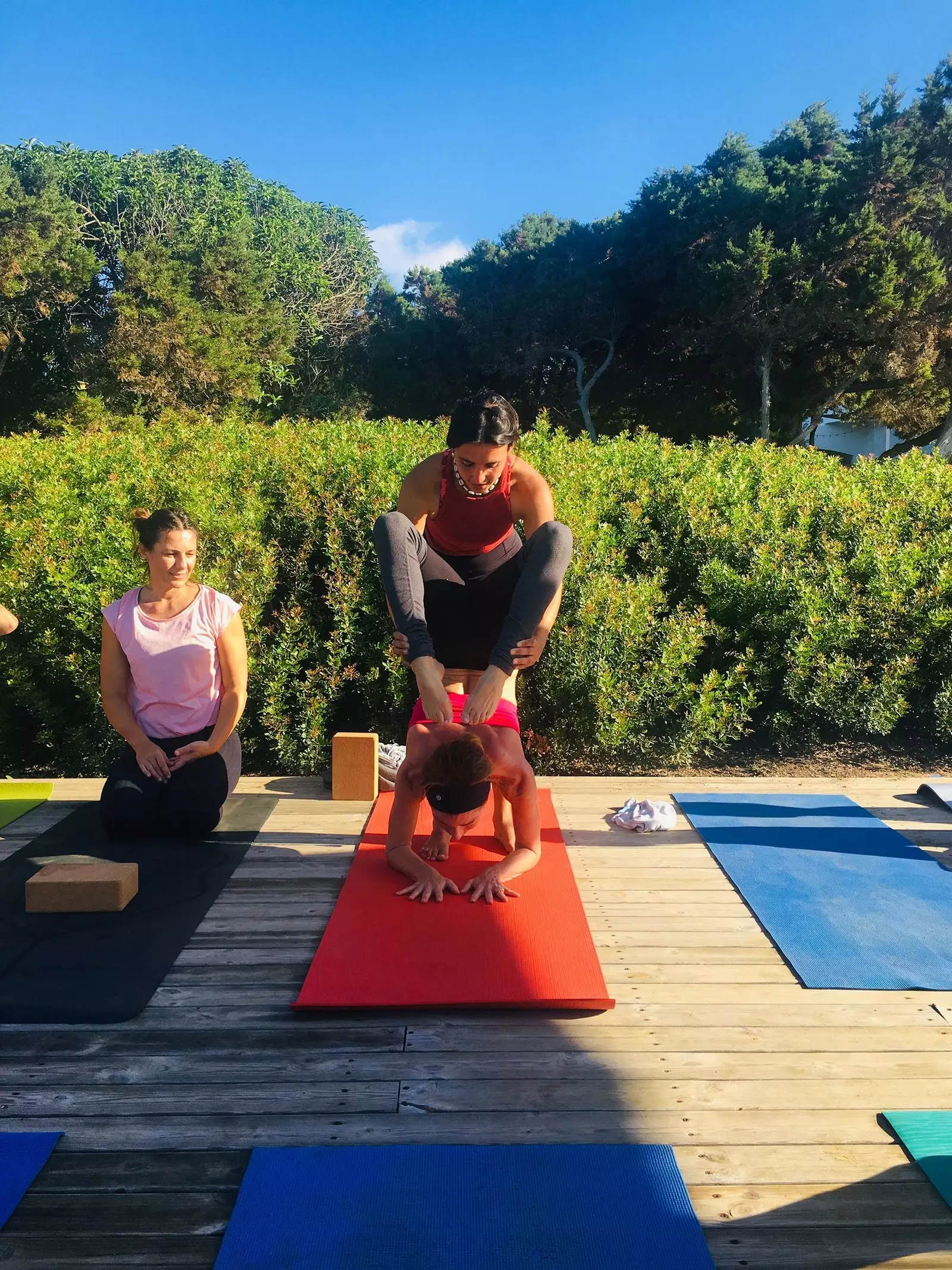 Sara helpt een studente met een asana.