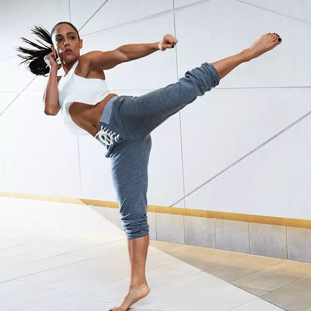 A person trains with one leg and one arm stretched out in a fighting stance