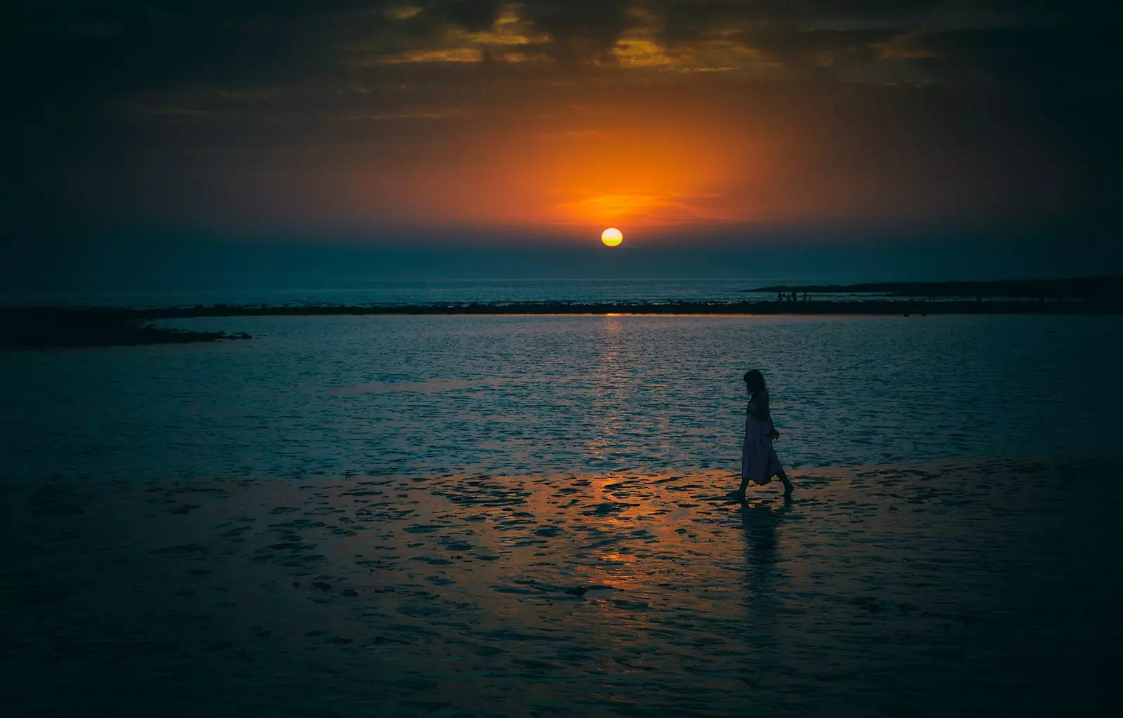 Conil de la Frontera의 El Palmar 해변에서 일몰 동안 여성