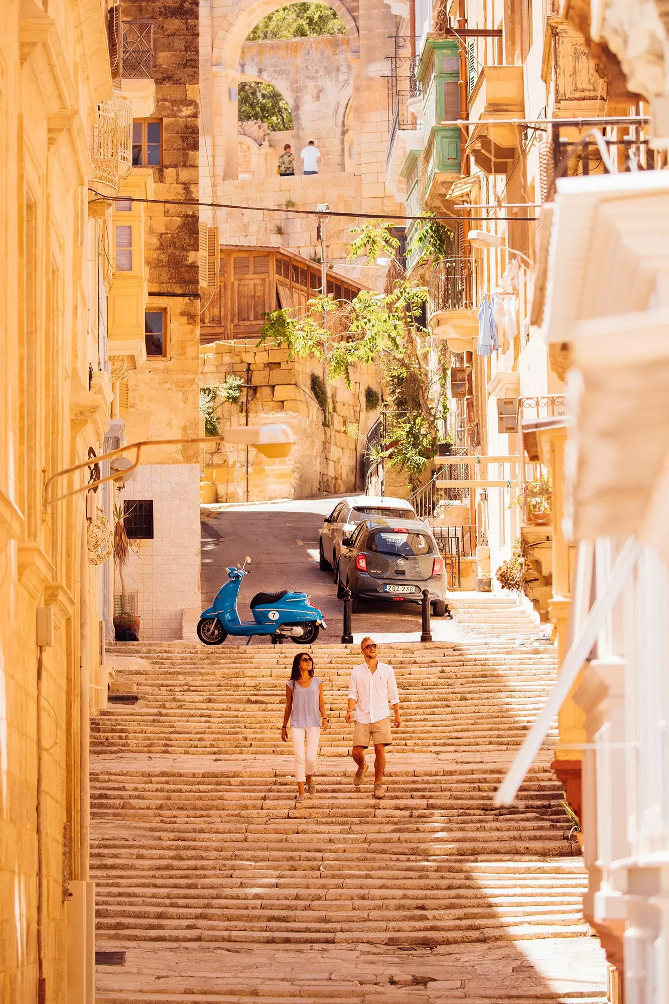 Wageni wawili wanashuka ngazi kupitia mitaa ya Valletta.