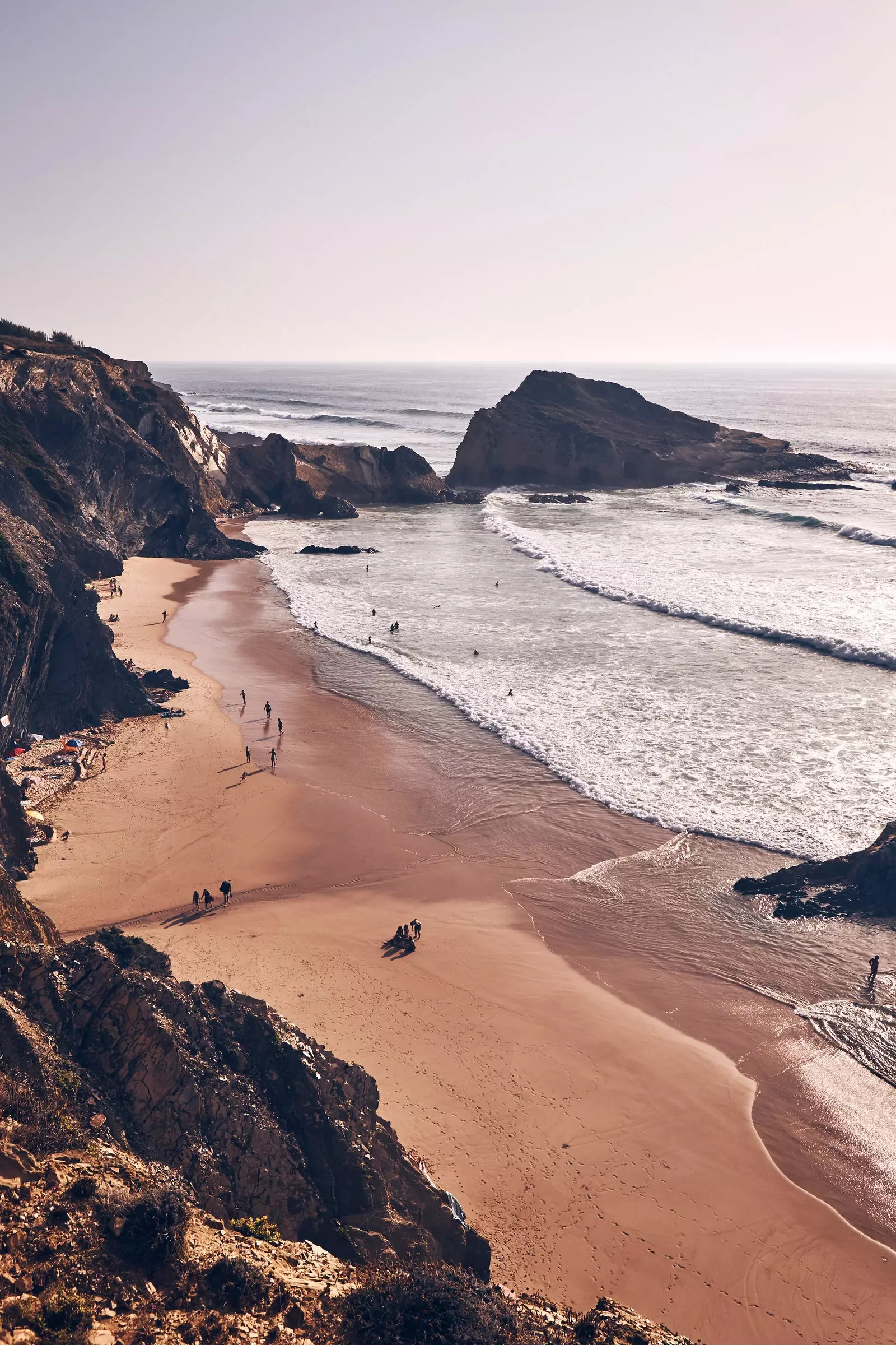 Praia de areia no sopé de um penhasco