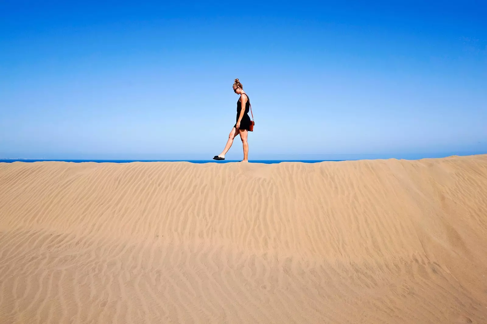 Cailín ag siúl timpeall Maspalomas