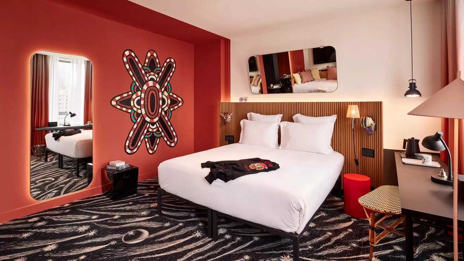 Murs rouges et moquette futuriste dans une chambre de l'hôtel Mama Shelter La Défense.