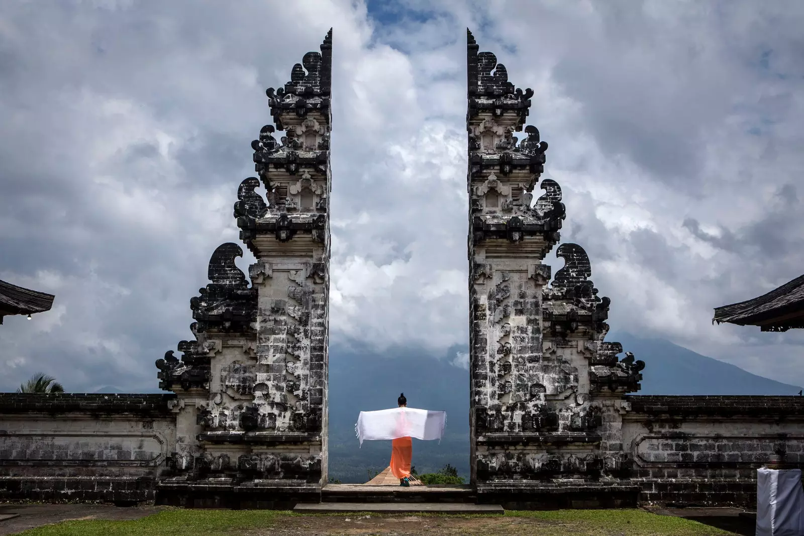 Person with his back facing the Gate of Heaven of the Pura Penataran Agung Lempuyang temple in Bali Indonesia