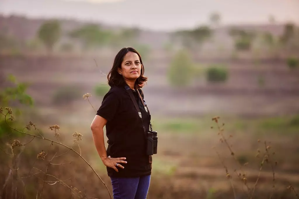 Krithi Karanth in posa davanti a un paesaggio di cespugli e alberi in India