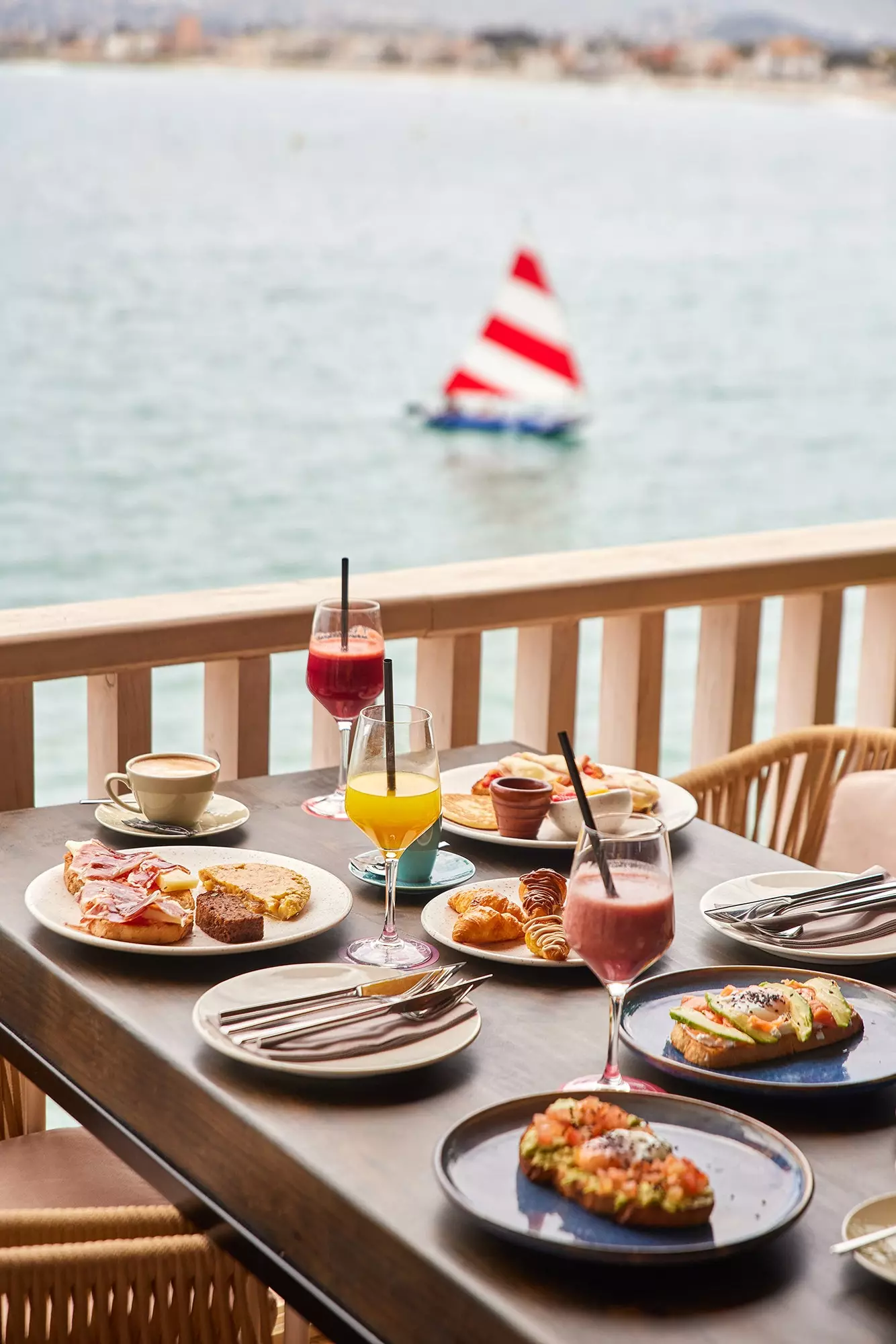 Frokostbord i Cala Bandida ved sjøen fylt med kaffe, juice, smoothies, avokadotoast, toast med bacon og...