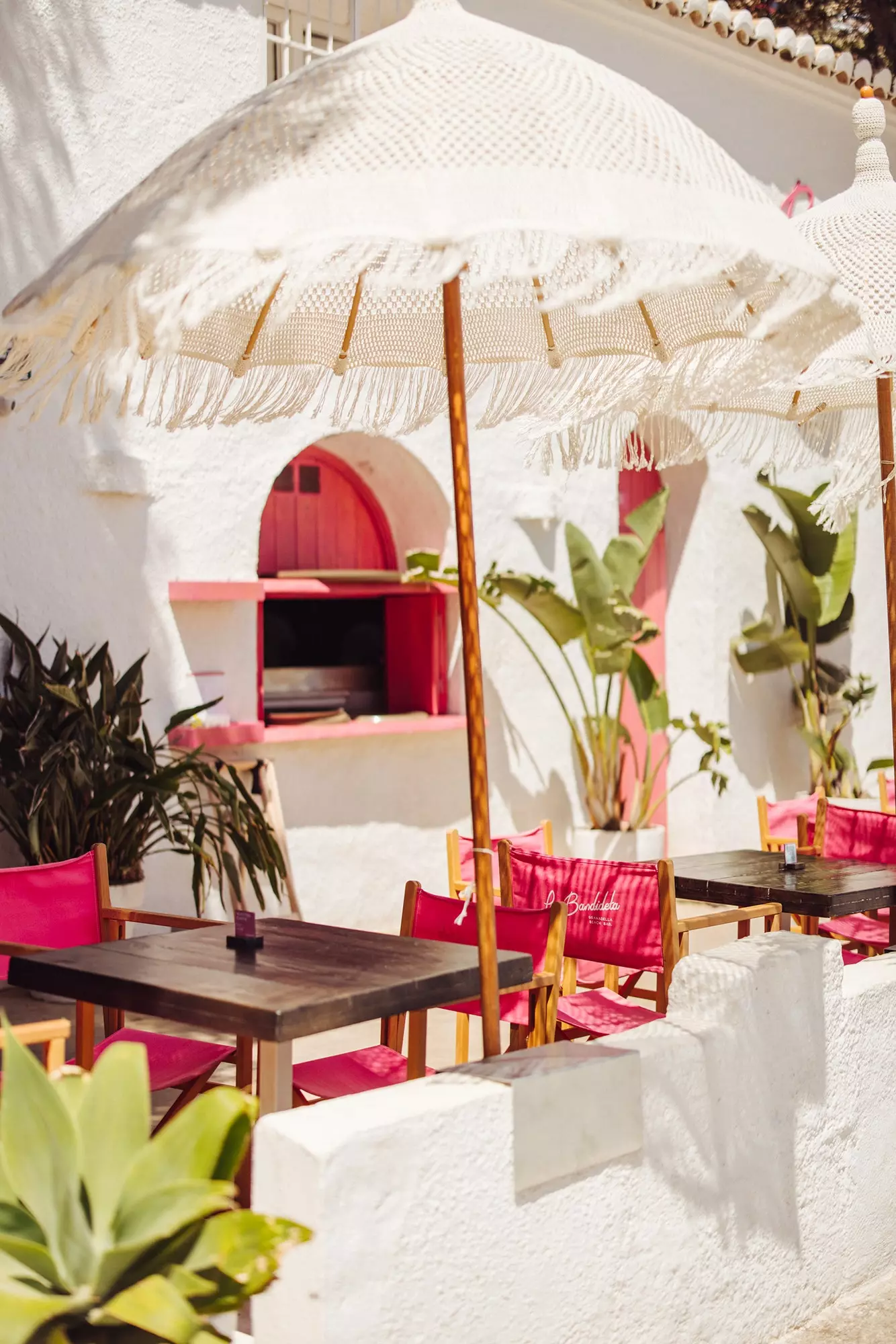 Fachada de La Bandideta decorada em cal branca com detalhes em rosa.