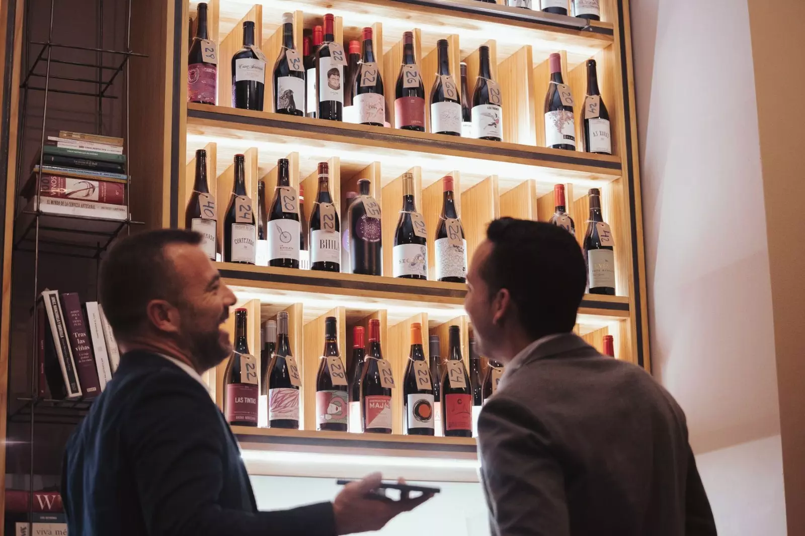 Bottle rack with customers in Vertical Wine Bar Shop