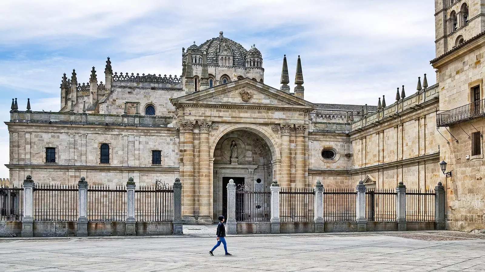 A woman passes in front of the Zamora cathedral