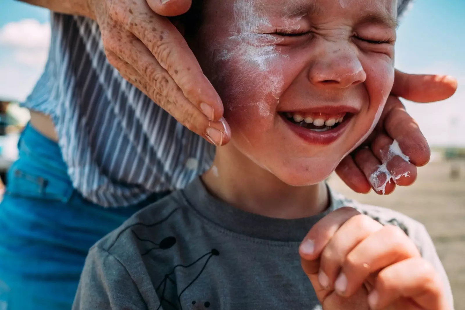 Junge Sonnencreme auftragen