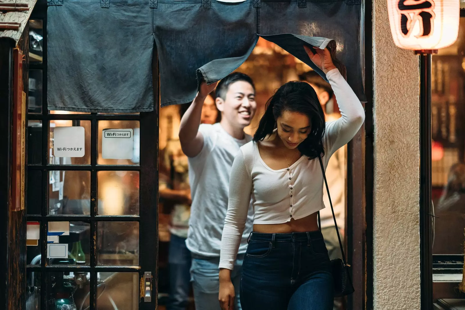 東京の居酒屋を出る女性