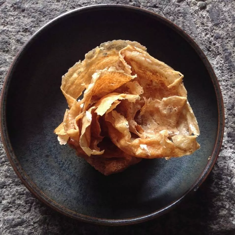 Craquelins de porc et manioc fumé avec réduction de miel de talnete au Quiltro