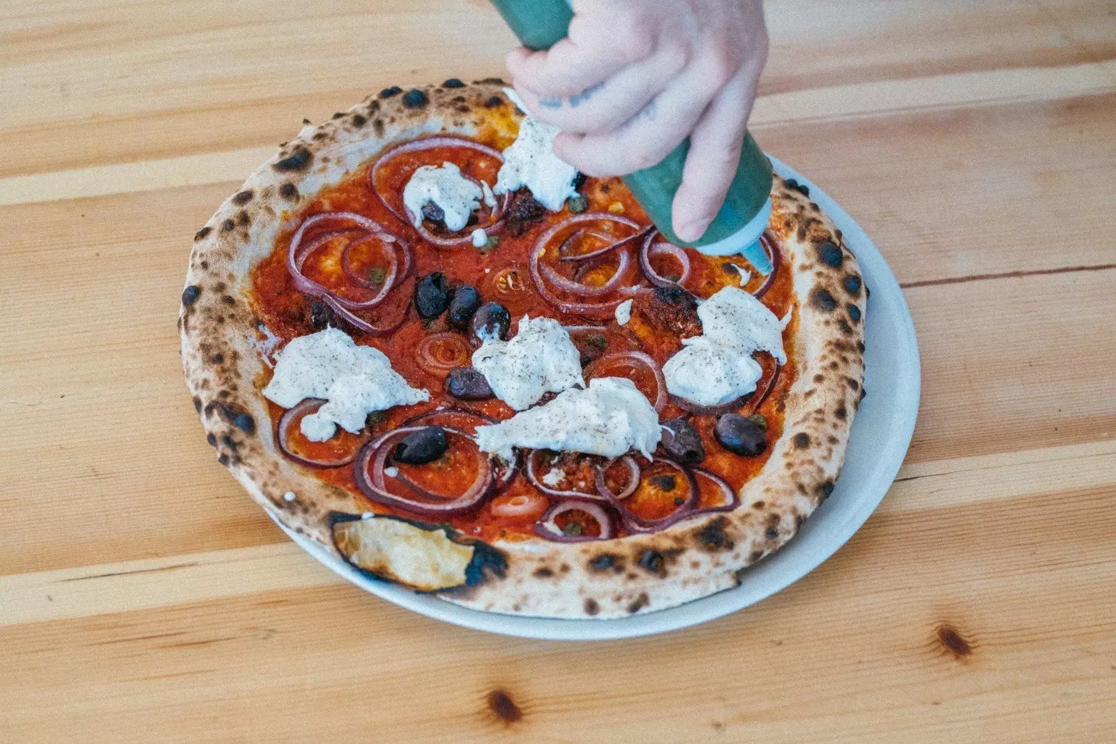 Blikje Pizzadeeg wordt handmatig gekneed.