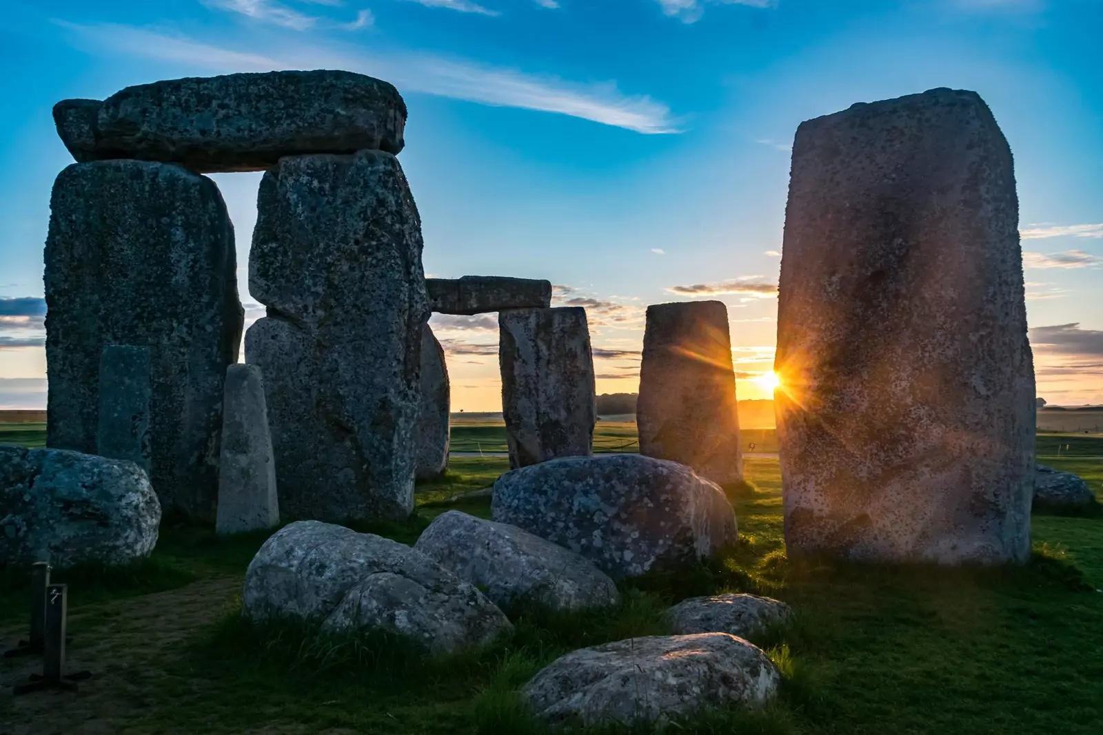 Slnko zarámované medzi sarsenovými kameňmi Stonehenge v Anglicku.