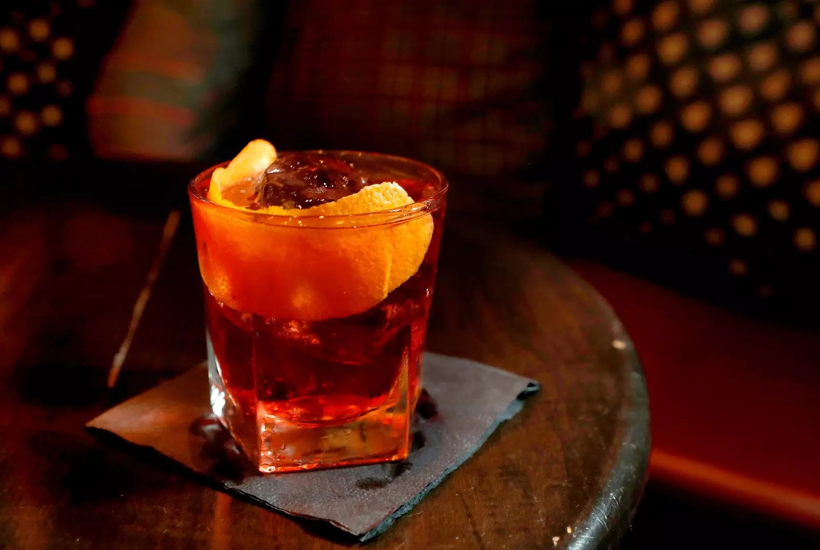 Glas Negroni mat senger rouder Äisfaarf an orange Schëller.