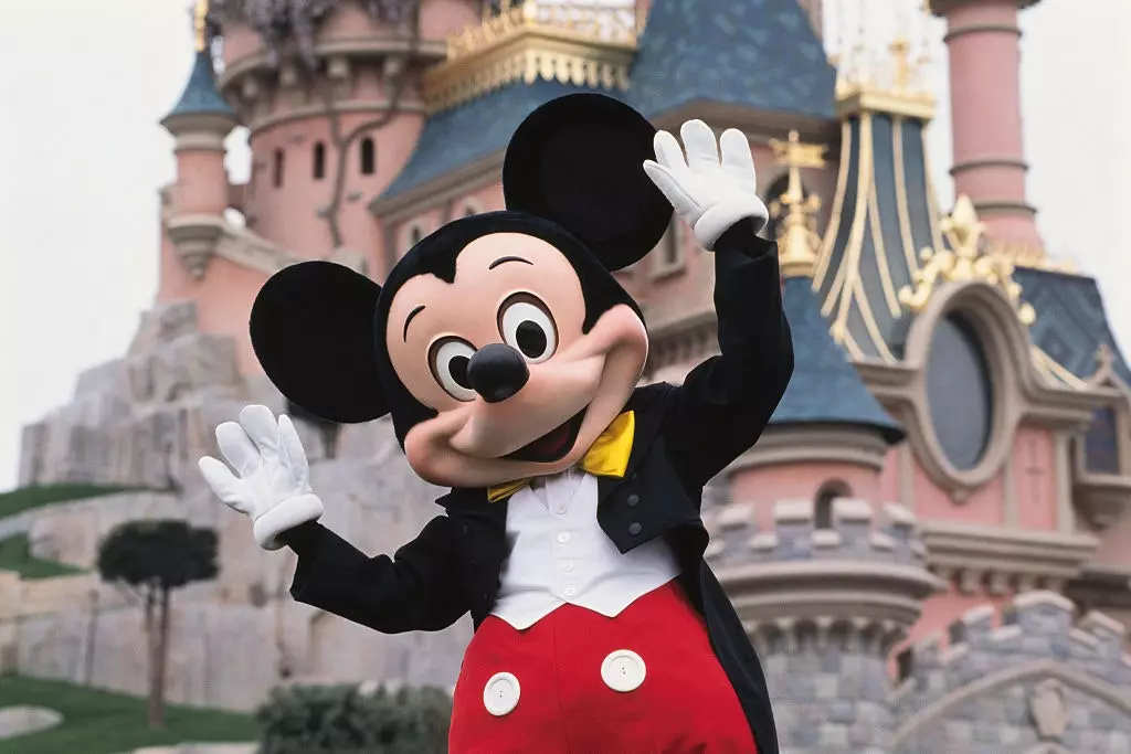 Mikki Maus Disneyland Resort Parisdə qala qarşısında poza verir.