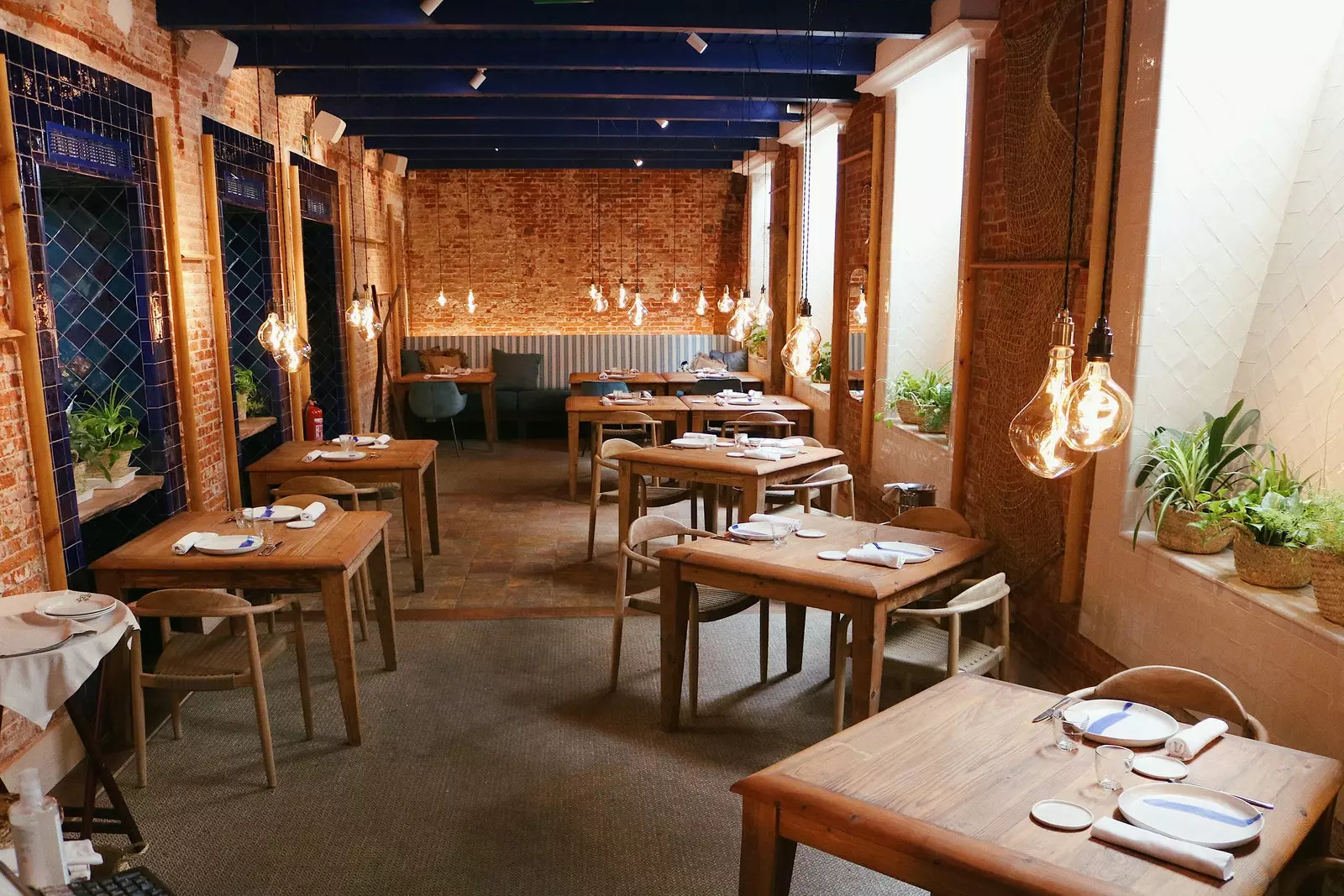 Interiorul Restaurantului Cadaqus cu iluminare slabă și căptușit cu lemn de răchită și gresie.