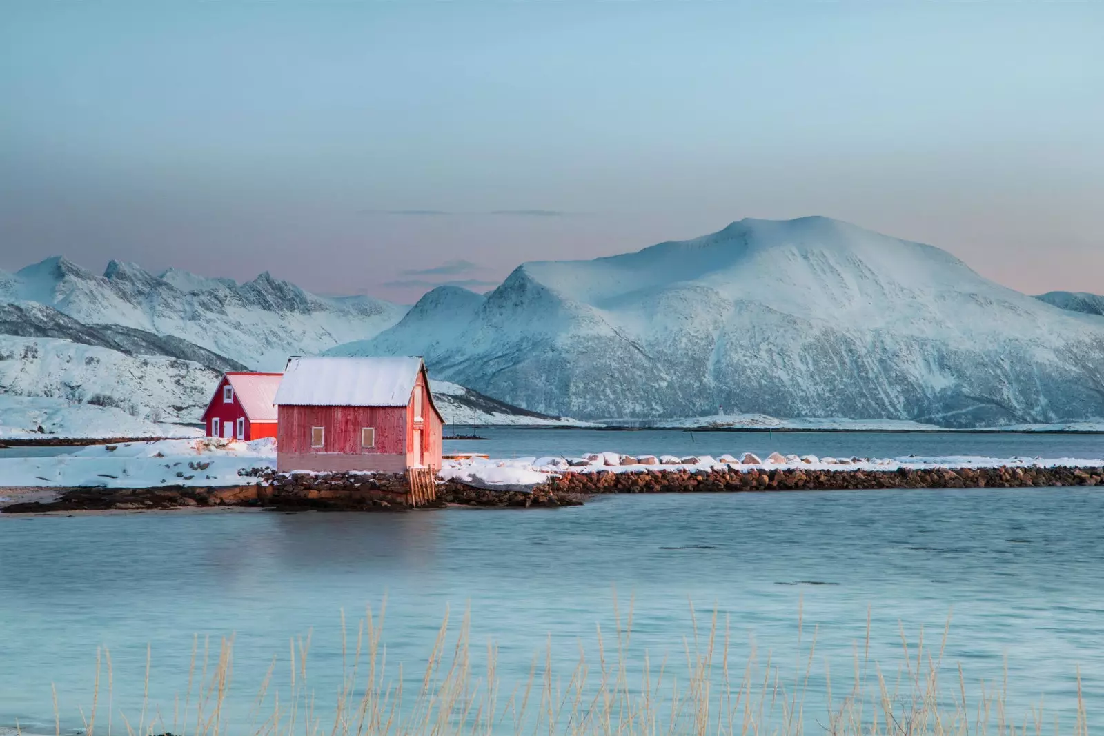 Sommarøy tussen de bergen en het bevroren water.