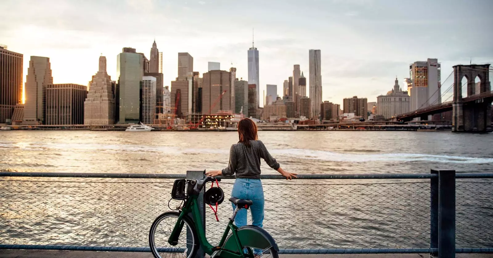 flicka med cykel framför skyskrapor new york