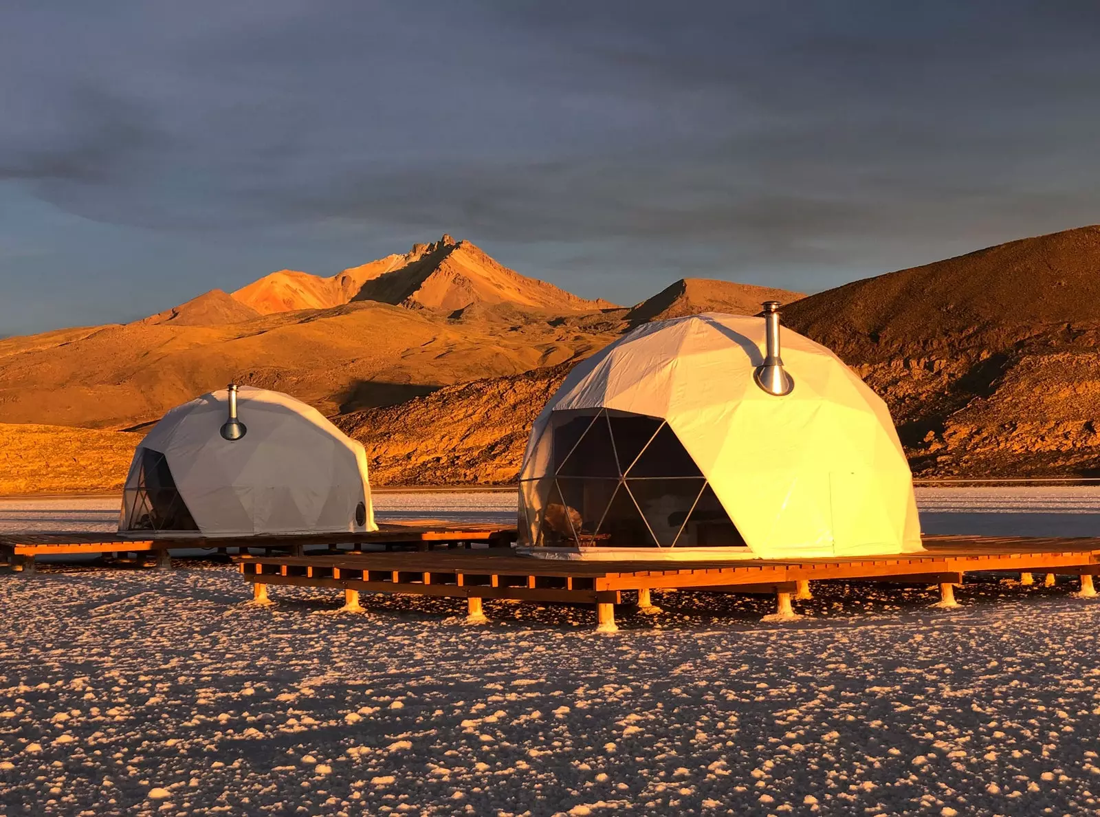 Kaksi Kachi Lodgen kupolia auringonlaskun aikaan Salar de Uyuni Boliviassa