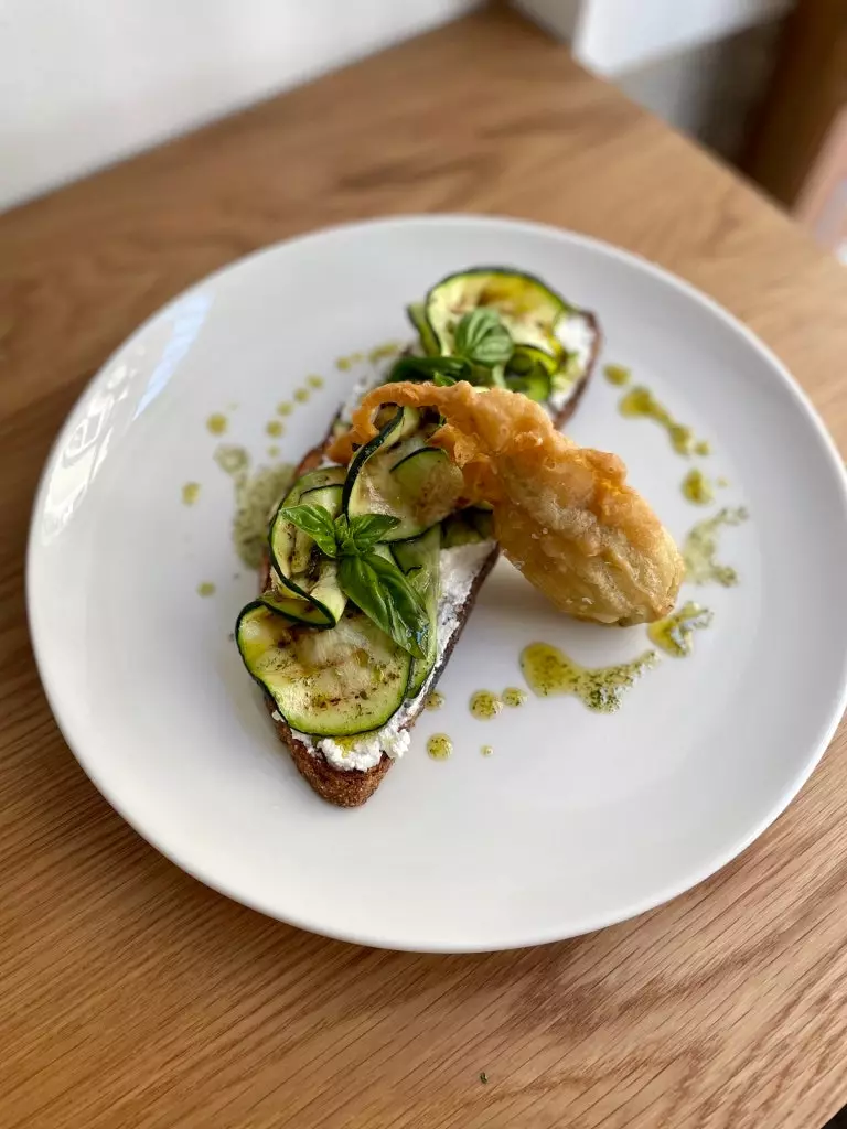 Hausgemachter Ricotta-Toast mit Zucchini und ihrer Blume in Tempura.