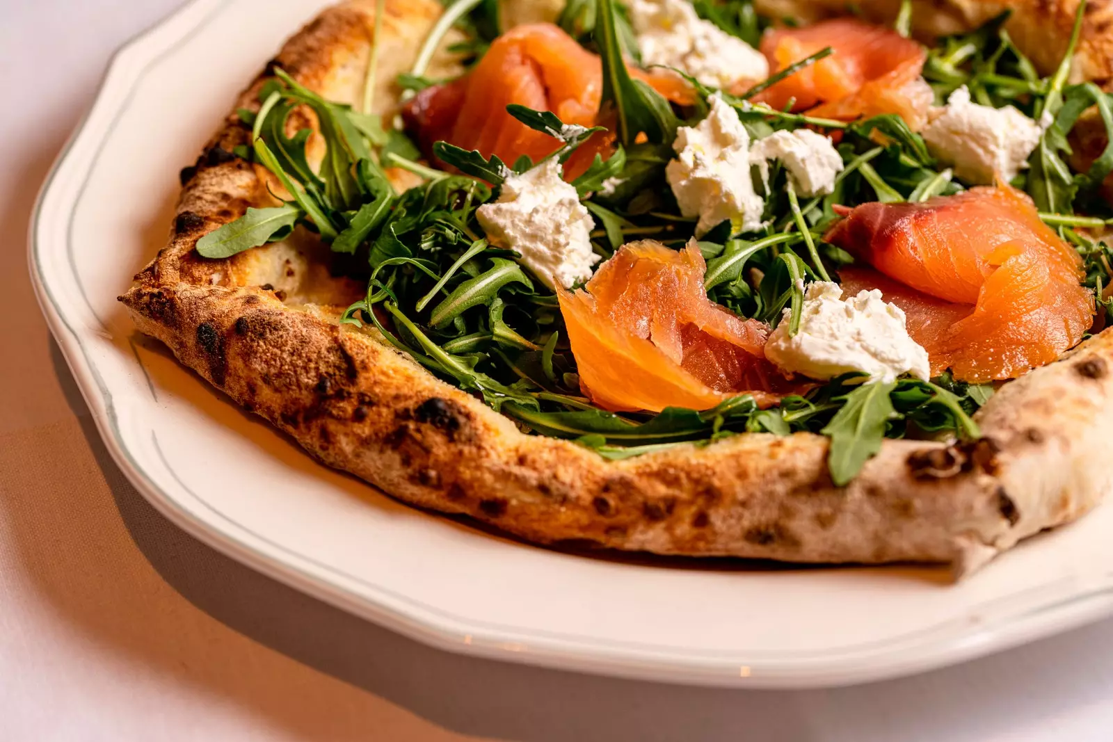 Pizza dengan arugula, keju rabiola dan salmon salai di Totó