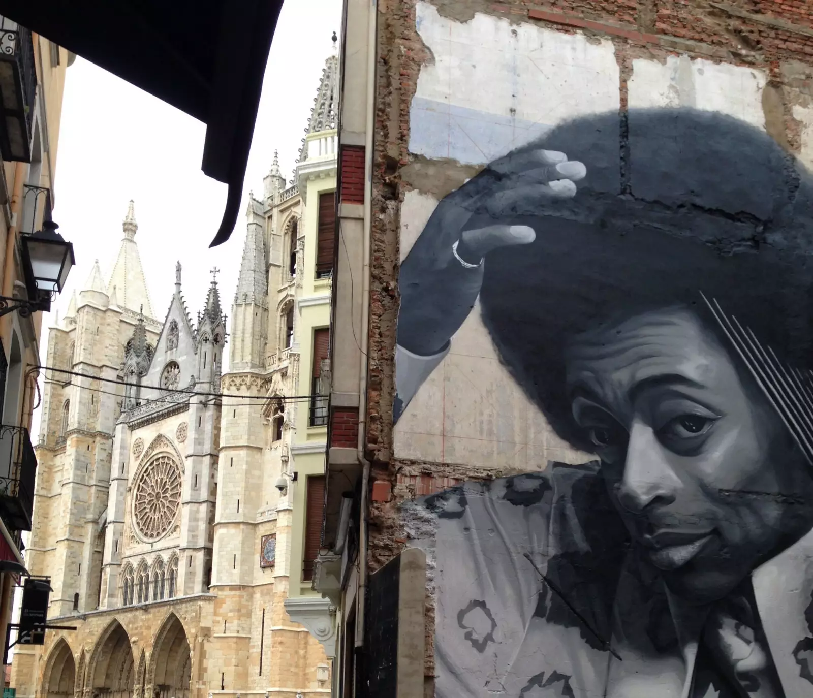 Graffiti de l'artiste Leons David Esteban sur la Calle de la Paloma avec la cathédrale de León en arrière-plan.