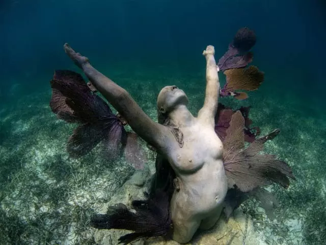 Een van de DeCaires-sculpturen in Cancun die samensmelten met de natuur en de zee