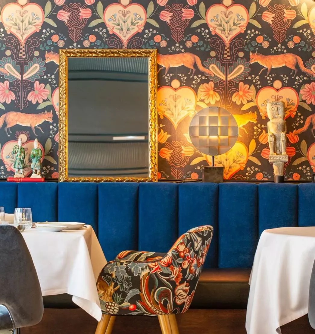 Wallpaper and upholstered armchairs in the Don Dimas restaurant