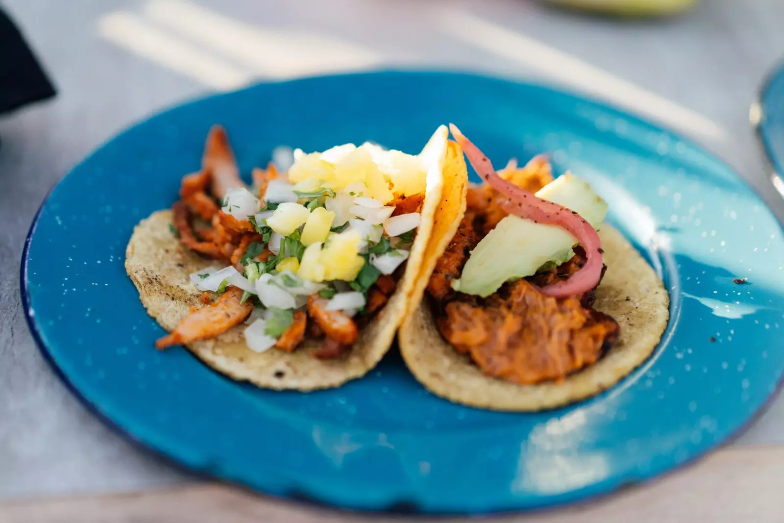 Mexican tacos on a blue plate.