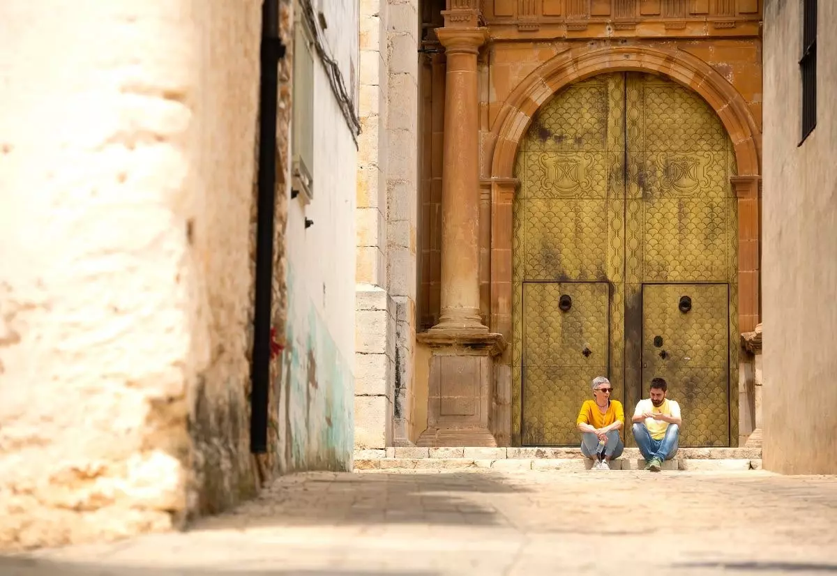 Assis à la porte de l'église paroissiale de Benlloc